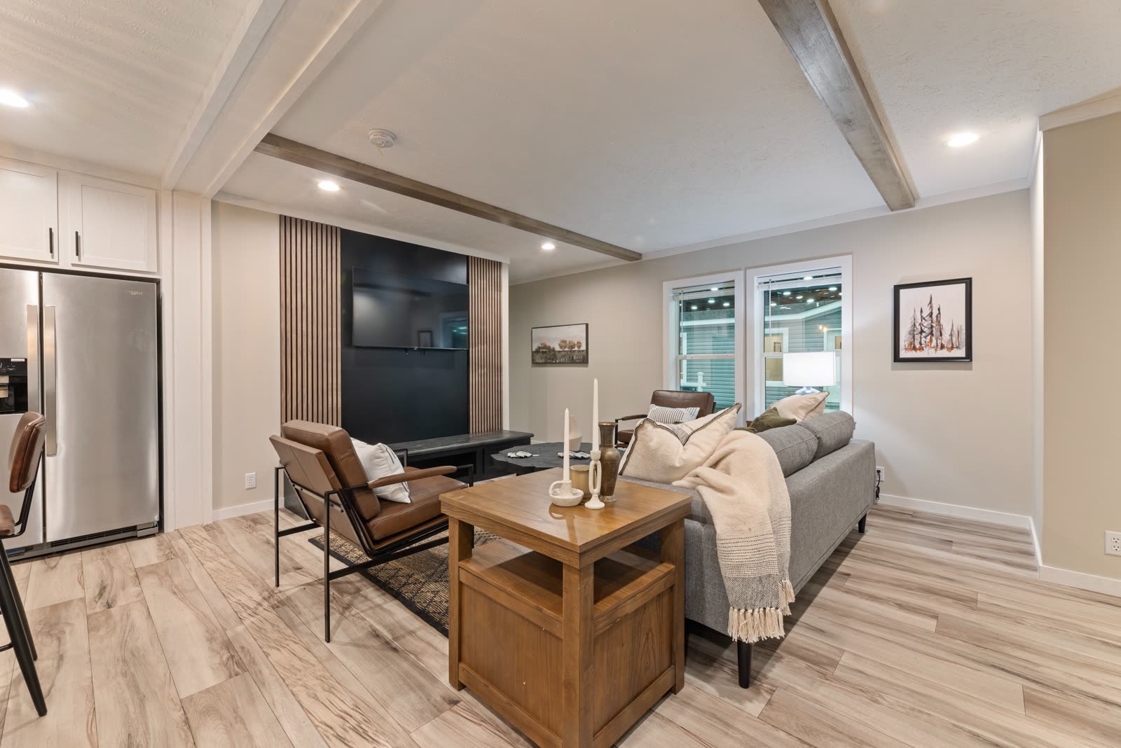 Living room toward the refrigerator. Leather chair, side table, television wall.