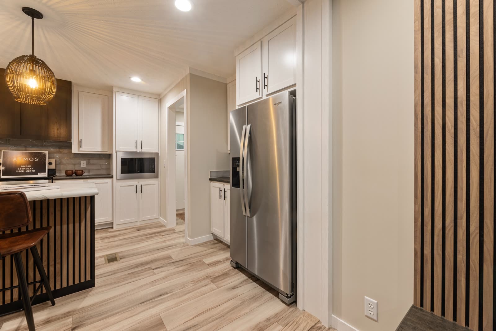 Kitchen. Refrigerator, microwave, and the slat wall.