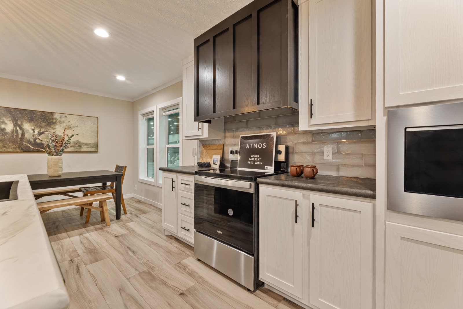Kitchen. Range, dark hood, dining table by the window.