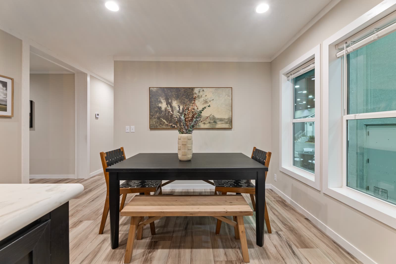 Dining. Black table with bench and chairs beside the windows.