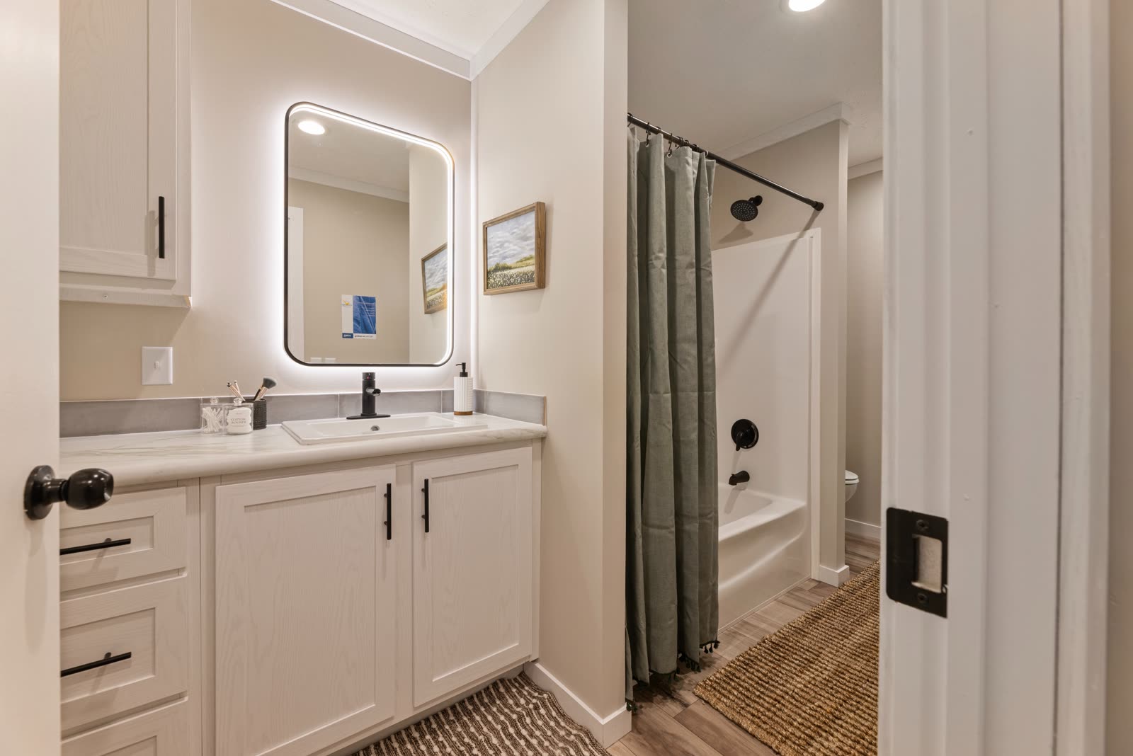 Bath 2. Vanity with lighted mirror, tub and shower.