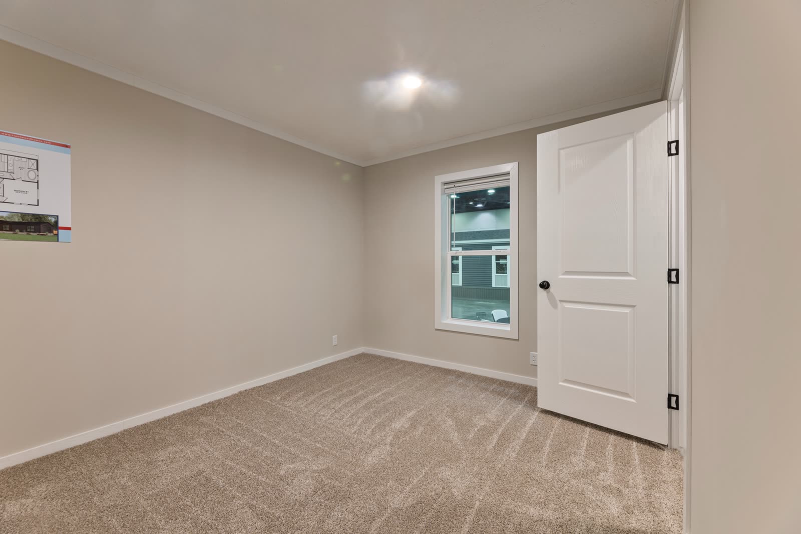 Secondary bedroom. Empty, carpet, window to the lot.