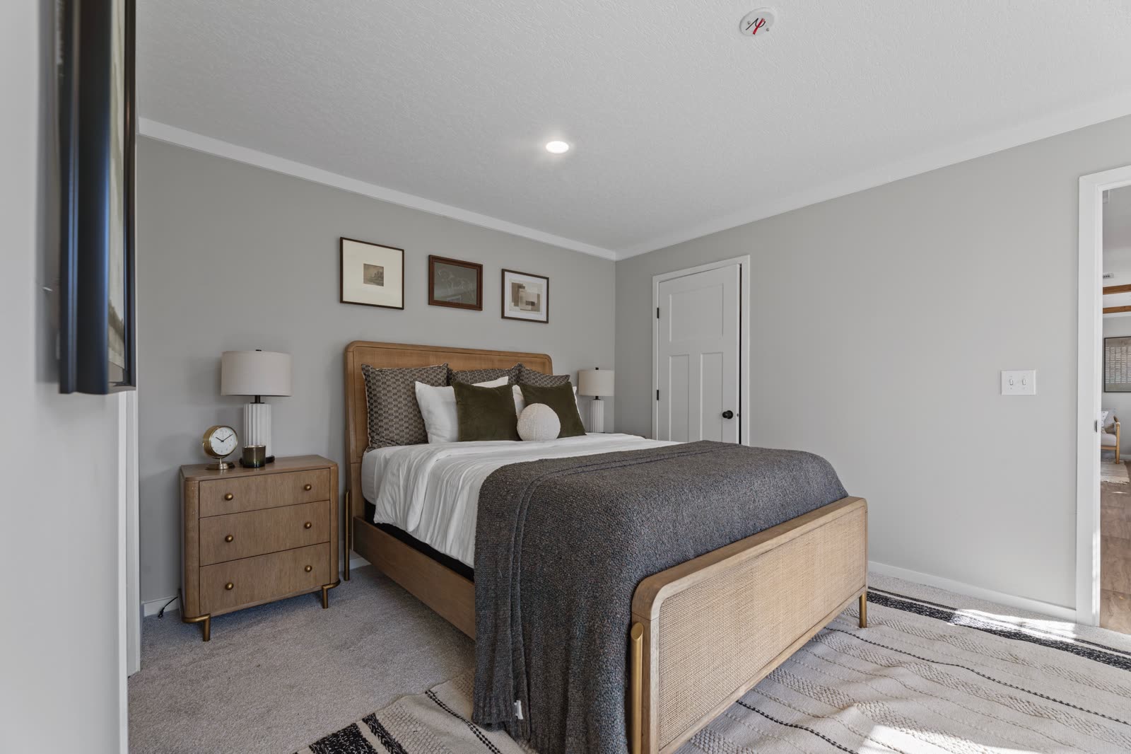 Bedroom 1. Bed and nightstand, wall-mounted television at left.