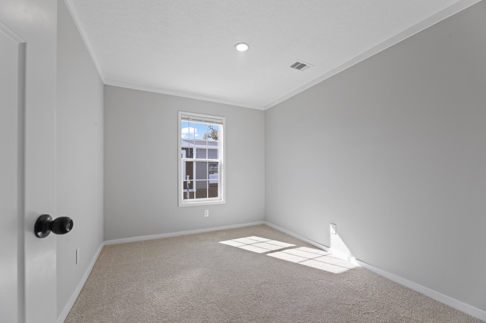 Bedroom 2. Empty, carpet, window to the lot.