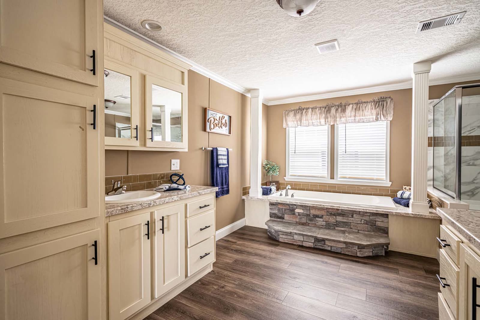 Master bath. Vanity with medicine cabinet, columns, soaking tub, shower.