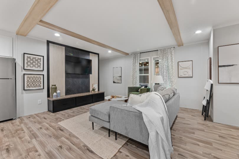 Living room. Grey sectional, slat television wall, refrigerator at left.