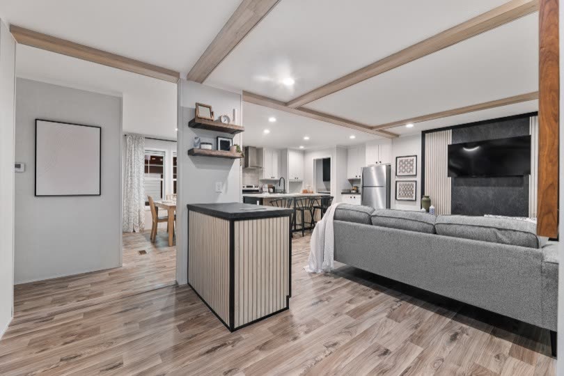 Inside the front door. Slat console ahead, living room to the right, kitchen beyond.