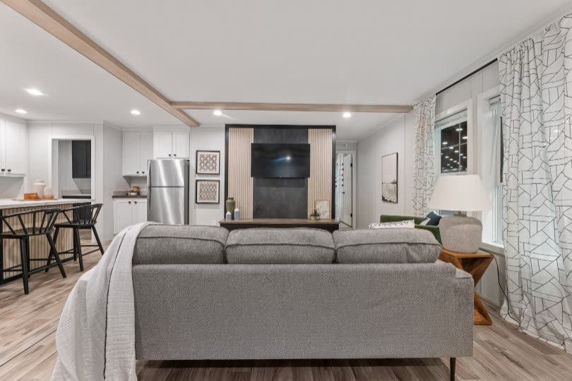 Living room from behind the sofa. Television wall, kitchen at left.