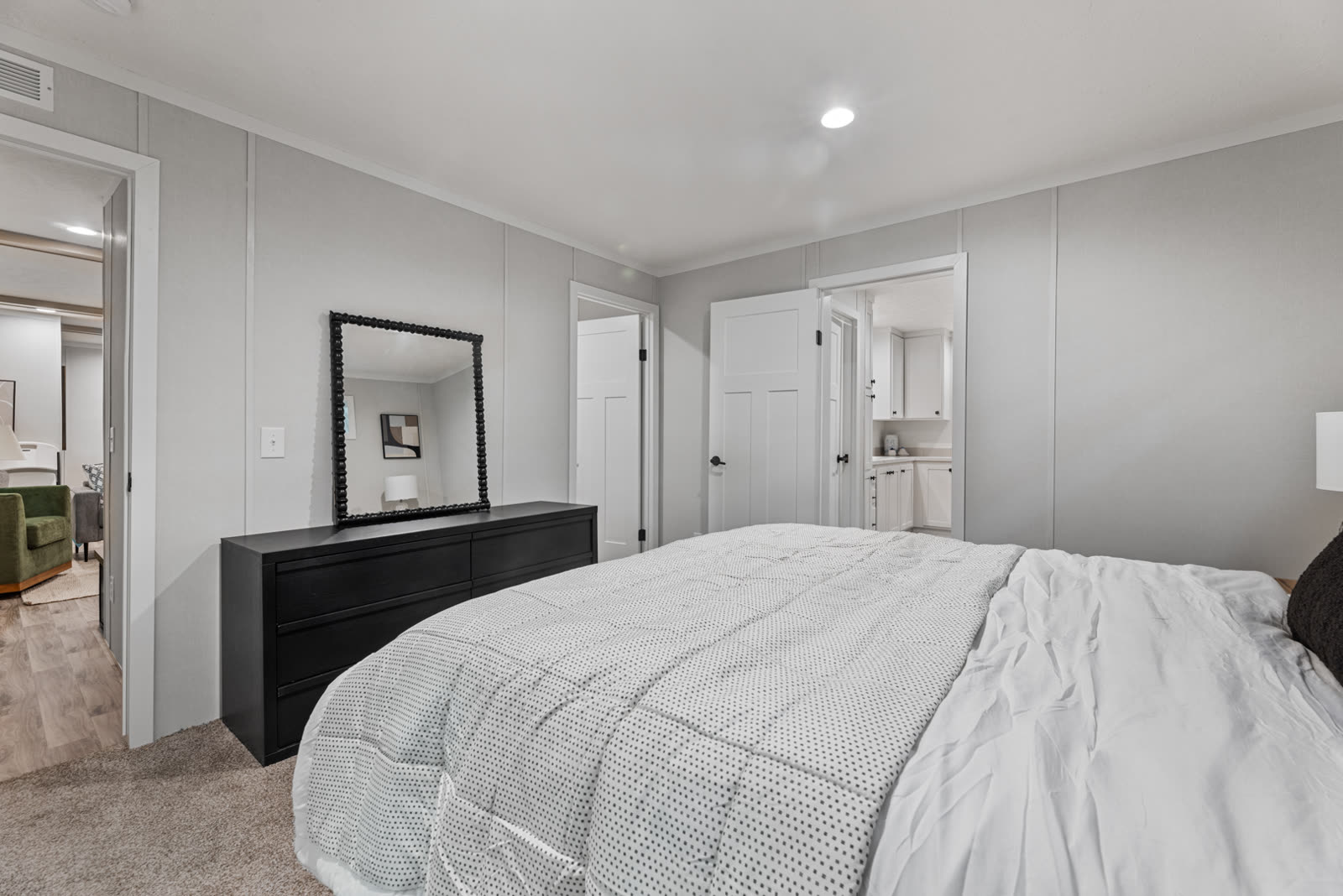 Bedroom 1. Black dresser with mirror, doors to the living room and Bath 1.