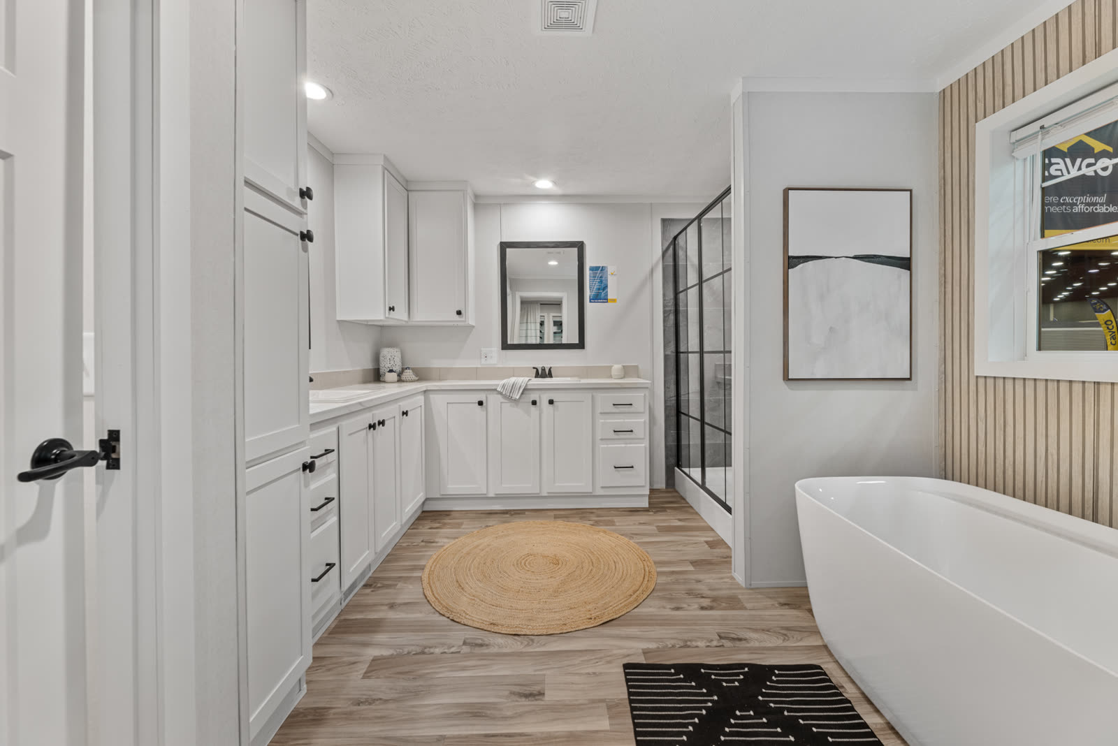 Bath 1 from the doorway. L-shaped vanity, glass shower, freestanding tub.