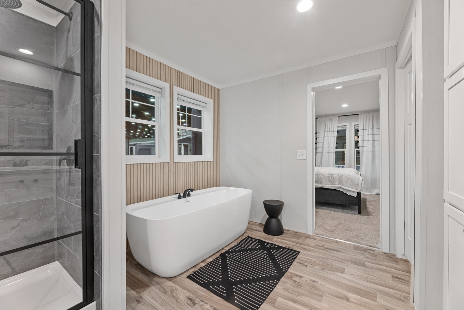 Bath 1. Tiled shower, freestanding tub under the window, door to Bedroom 1.