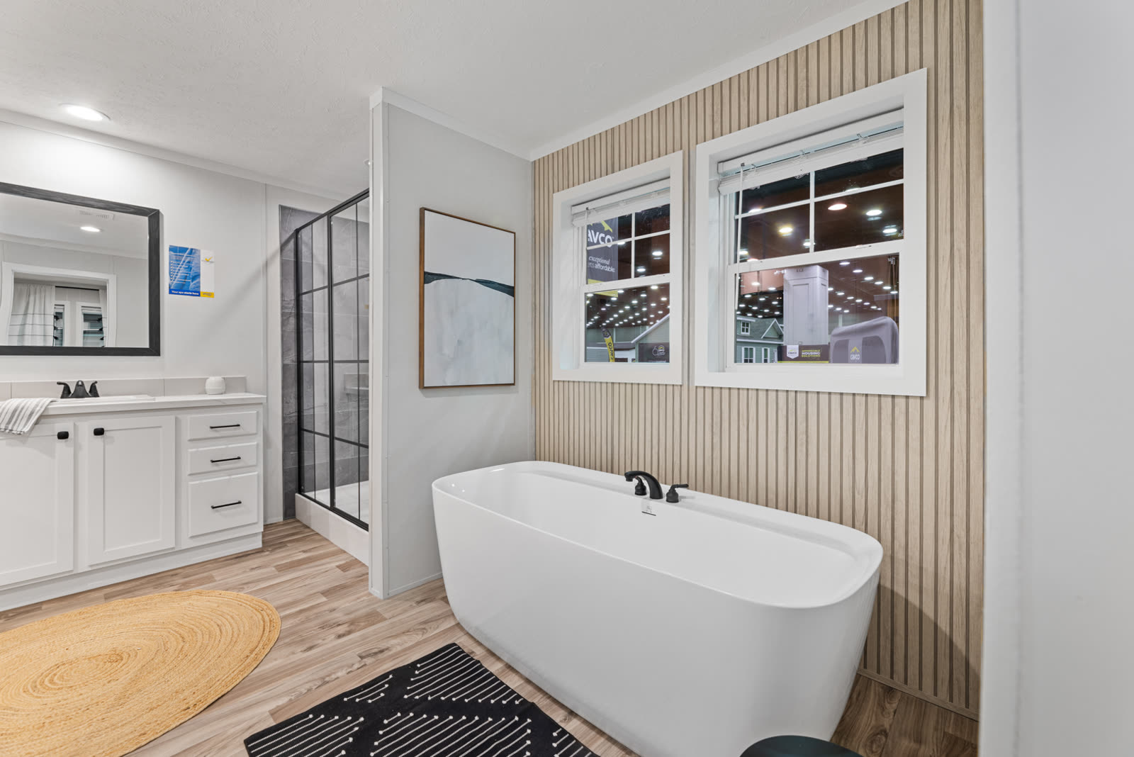Bath 1. Vanity, shower, tub under the windows, slat wainscot.