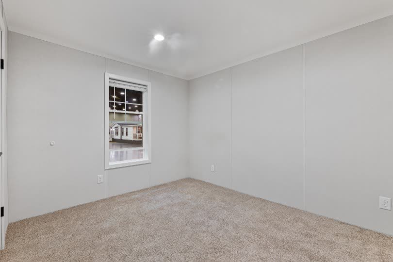 Secondary bedroom. Empty, carpet, window to the lot.