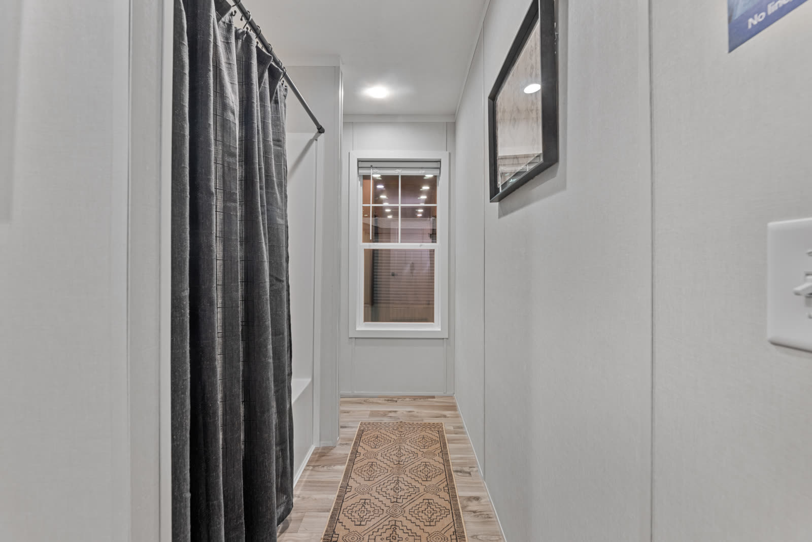Bath 2. Tub with shower curtain, window, runner.