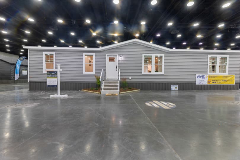 Exterior. The home on the show floor, grey lap siding, front steps.