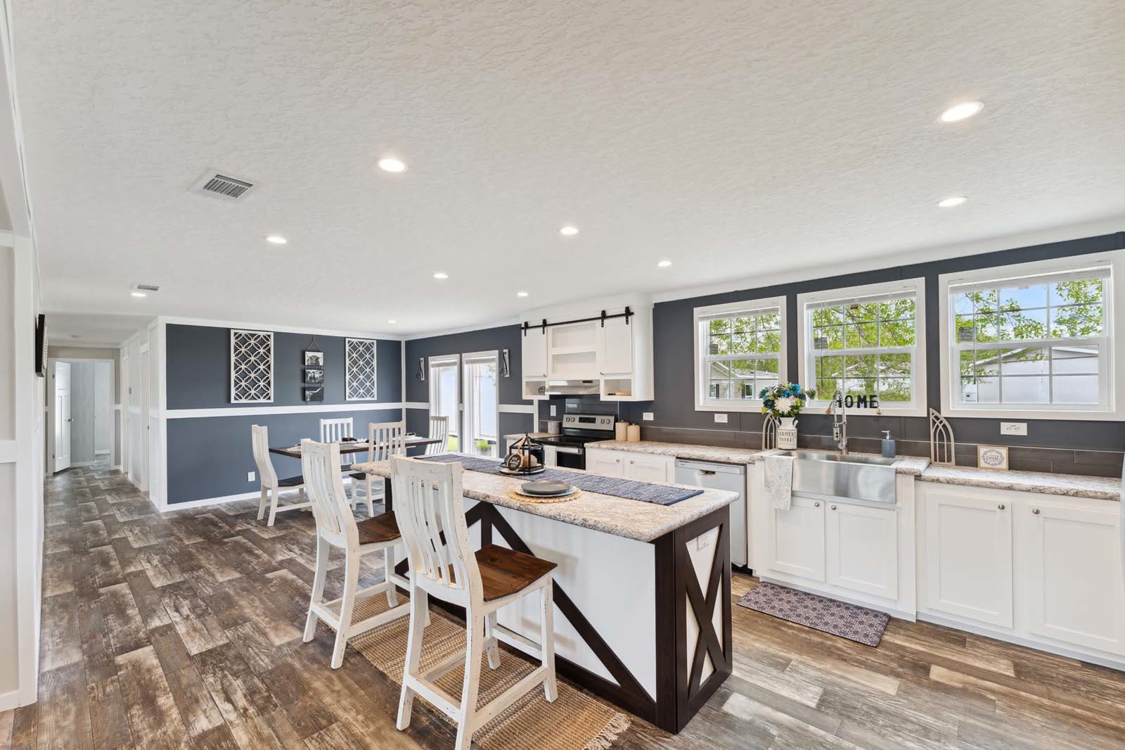 Kitchen and dining, first furnishing. Island with stools, farmhouse sink, dining table at left.