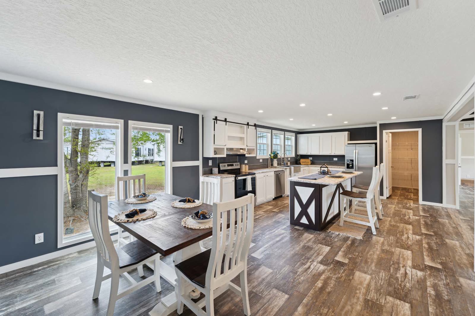 Dining, first furnishing. Table and four chairs by the window, kitchen beyond.