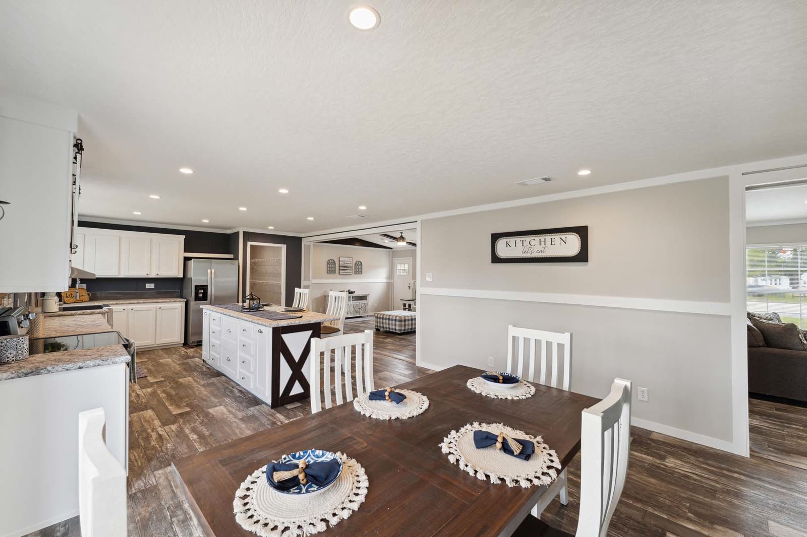Dining, first furnishing. Table with place settings, kitchen island beyond.