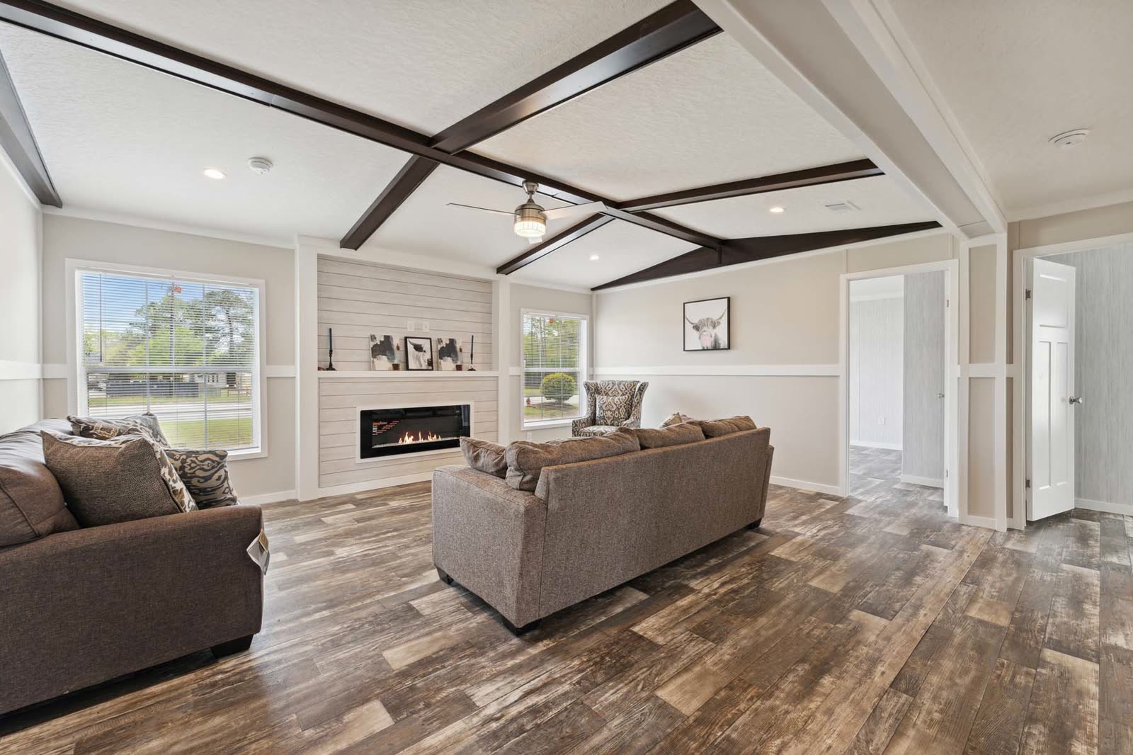 Family room, first furnishing. Two brown sofas, electric fireplace in a shiplap surround.