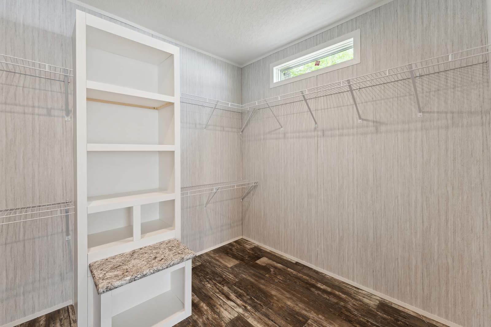 Walk-in closet. Wire shelving, built-in shelves and bench, high window.