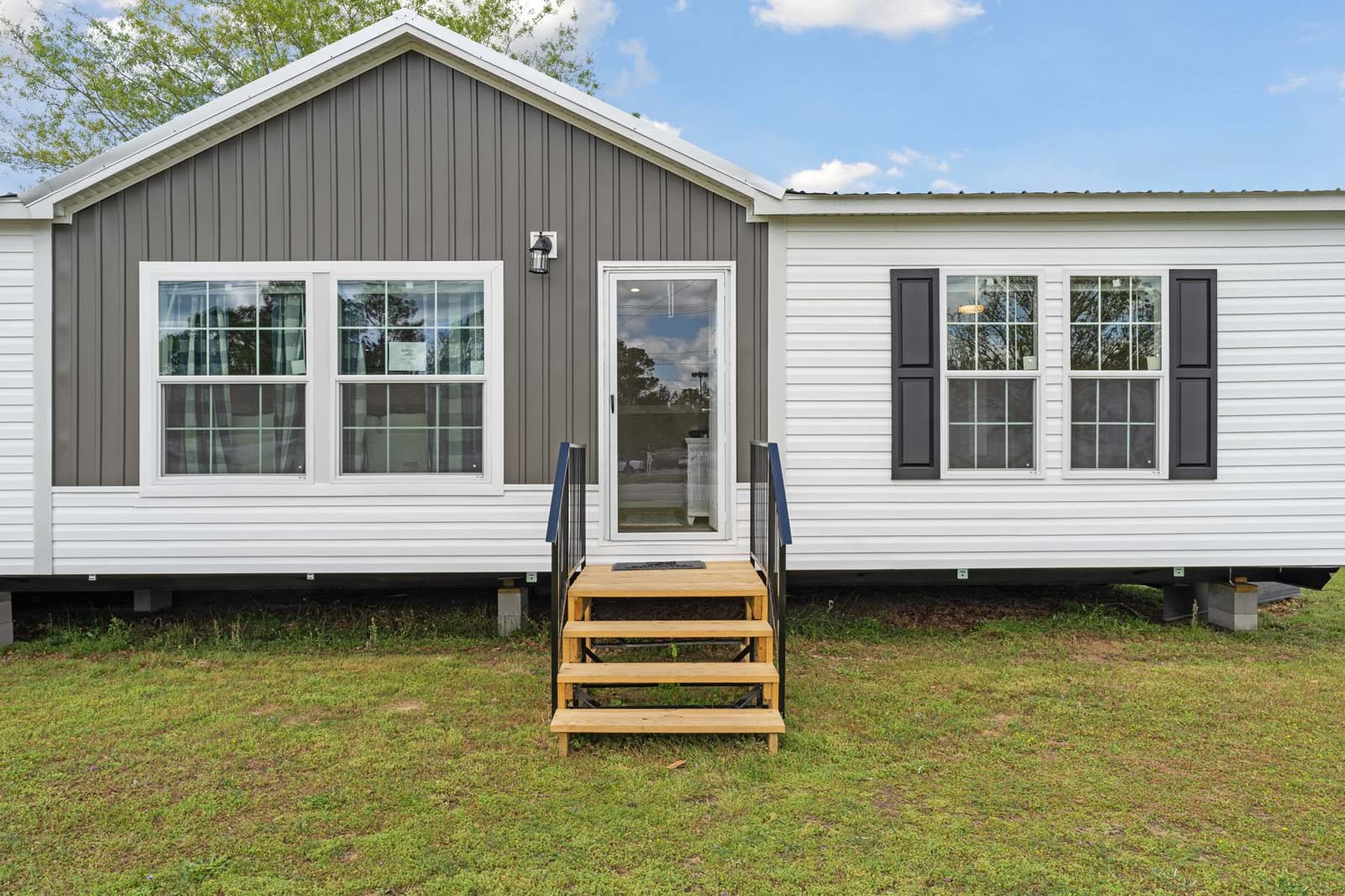 Exterior, rear. Grey gable, sliding glass door and steps.