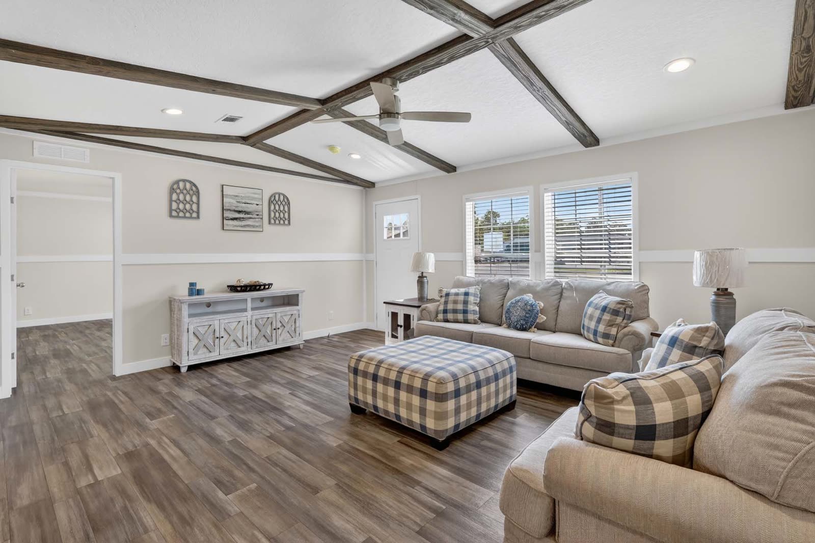 Living room. Console, sofa, plaid ottoman, window wall.
