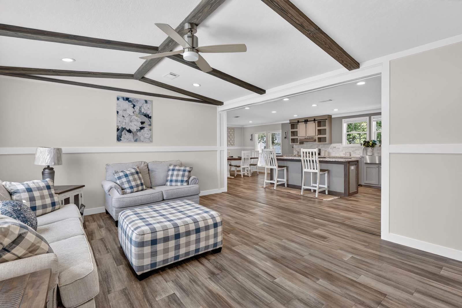 Living room toward the kitchen. Loveseat, ottoman, island beyond.