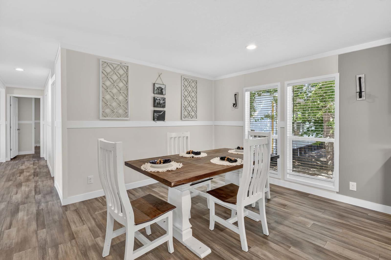 Dining. Table and four chairs, windows, hall at left.