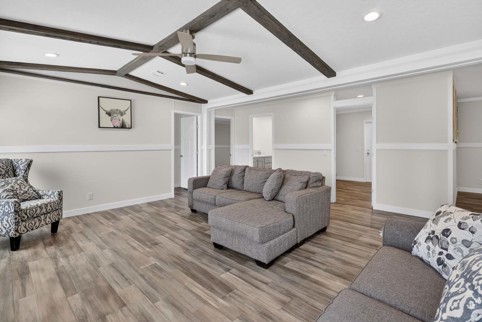 Family room. Sectional, armchair, bedroom doors beyond.