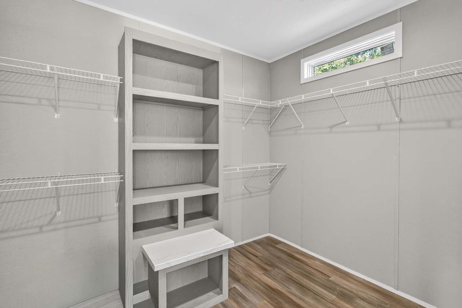 Walk-in closet. Wire shelving, built-in shelves and bench, high window.