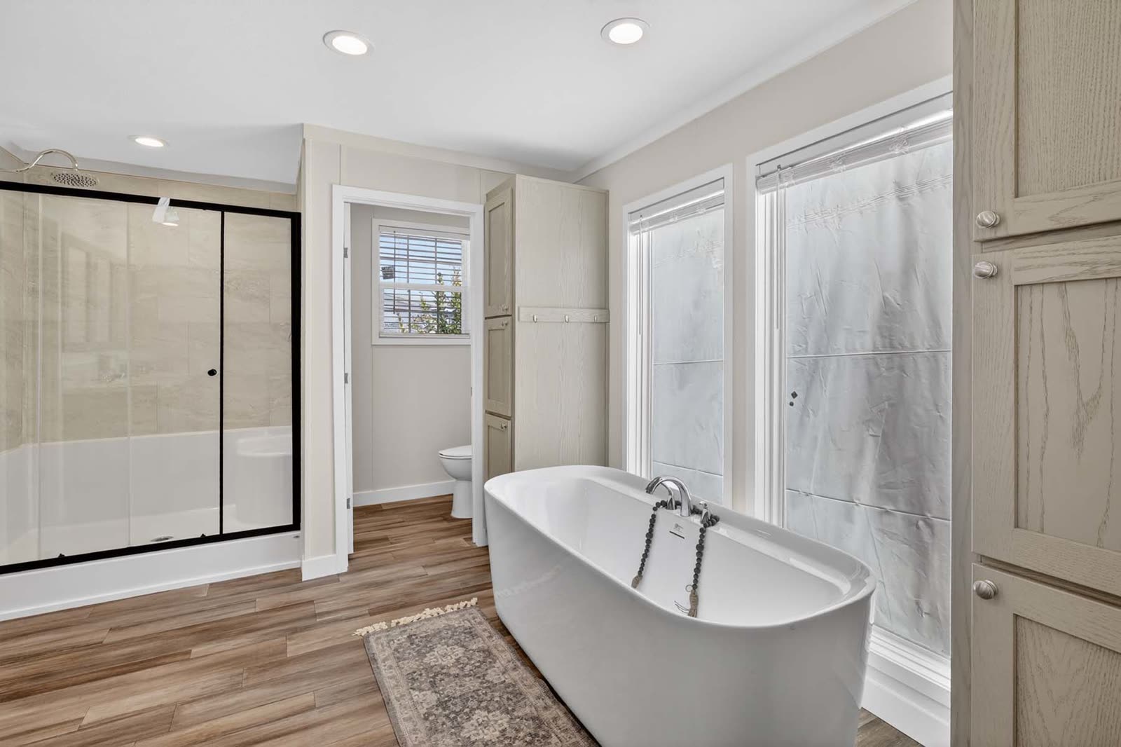 Primary bath. Freestanding tub, glass shower, water closet beyond.