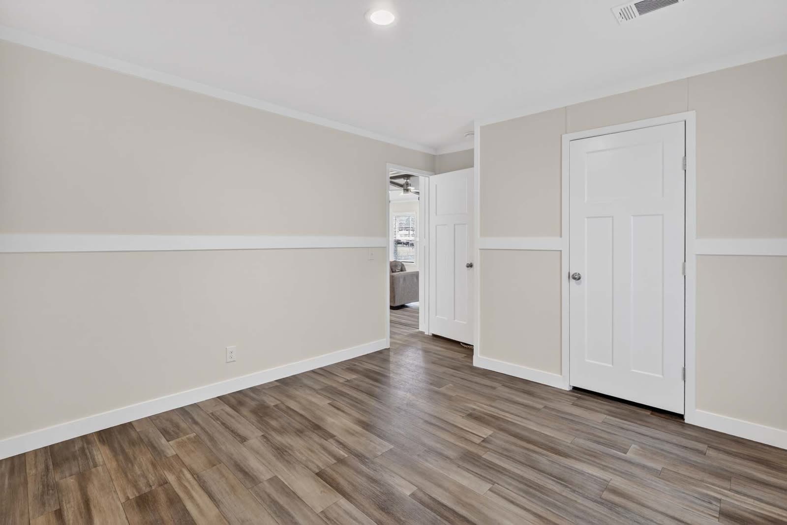 Bedroom 2. Empty, doors to the closet and the living room.