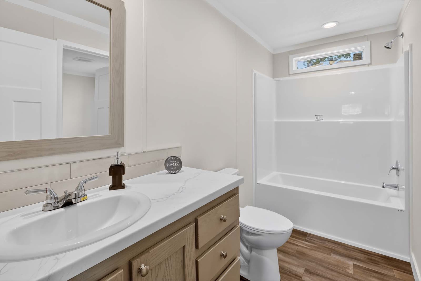Bath 2. Vanity, toilet, tub with shower, high window.