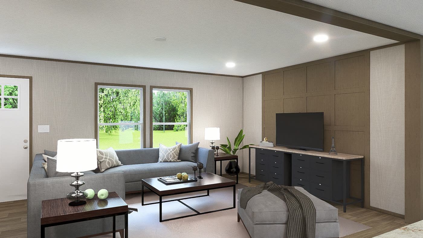 Family room. Grey sofa and ottoman, television on the wood-panel wall, windows to the lot.