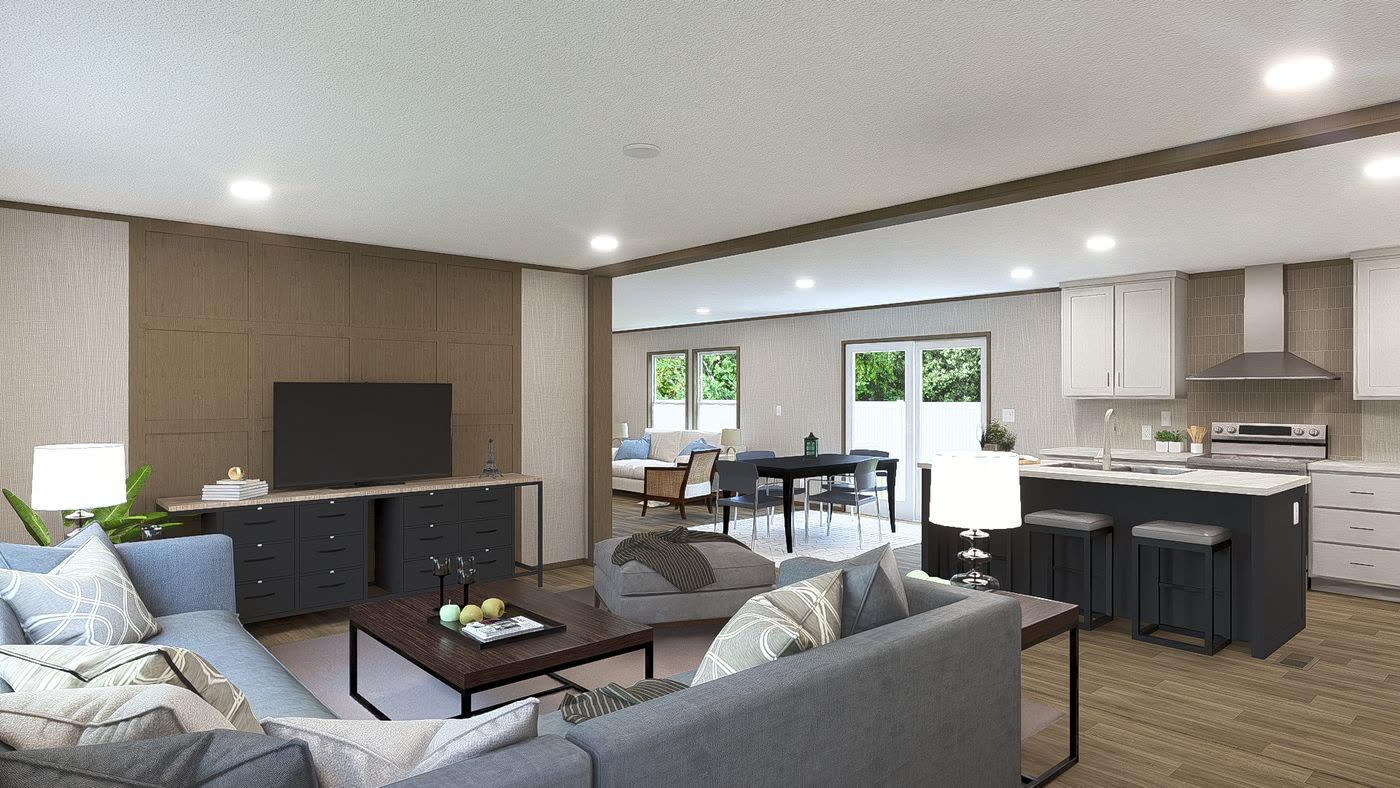 Living room toward the kitchen. Grey sectional, television wall, dining table and island beyond.