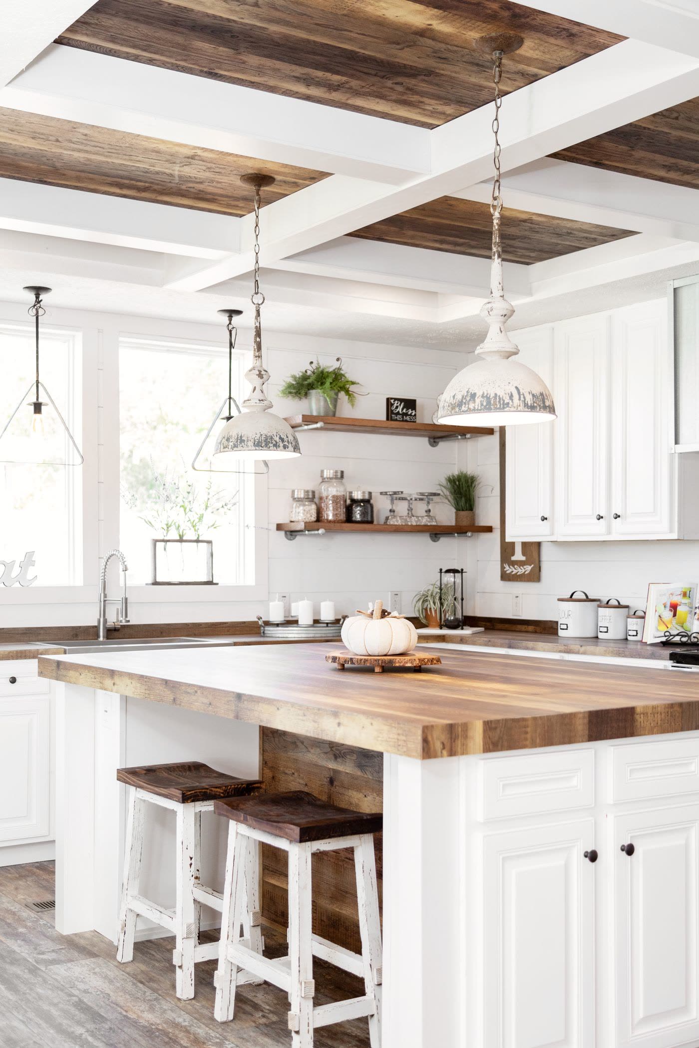 Kitchen. Island and stools, pendant lights, window over the sink.