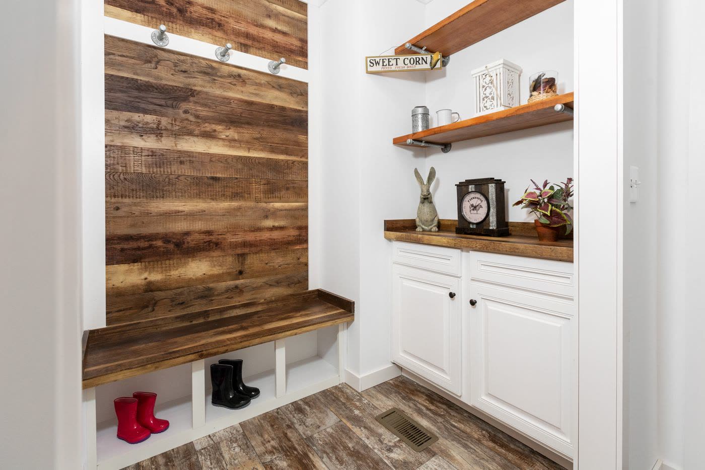 Mudroom. Wood plank wall with hooks, bench with boot cubbies, shelves over cabinets.