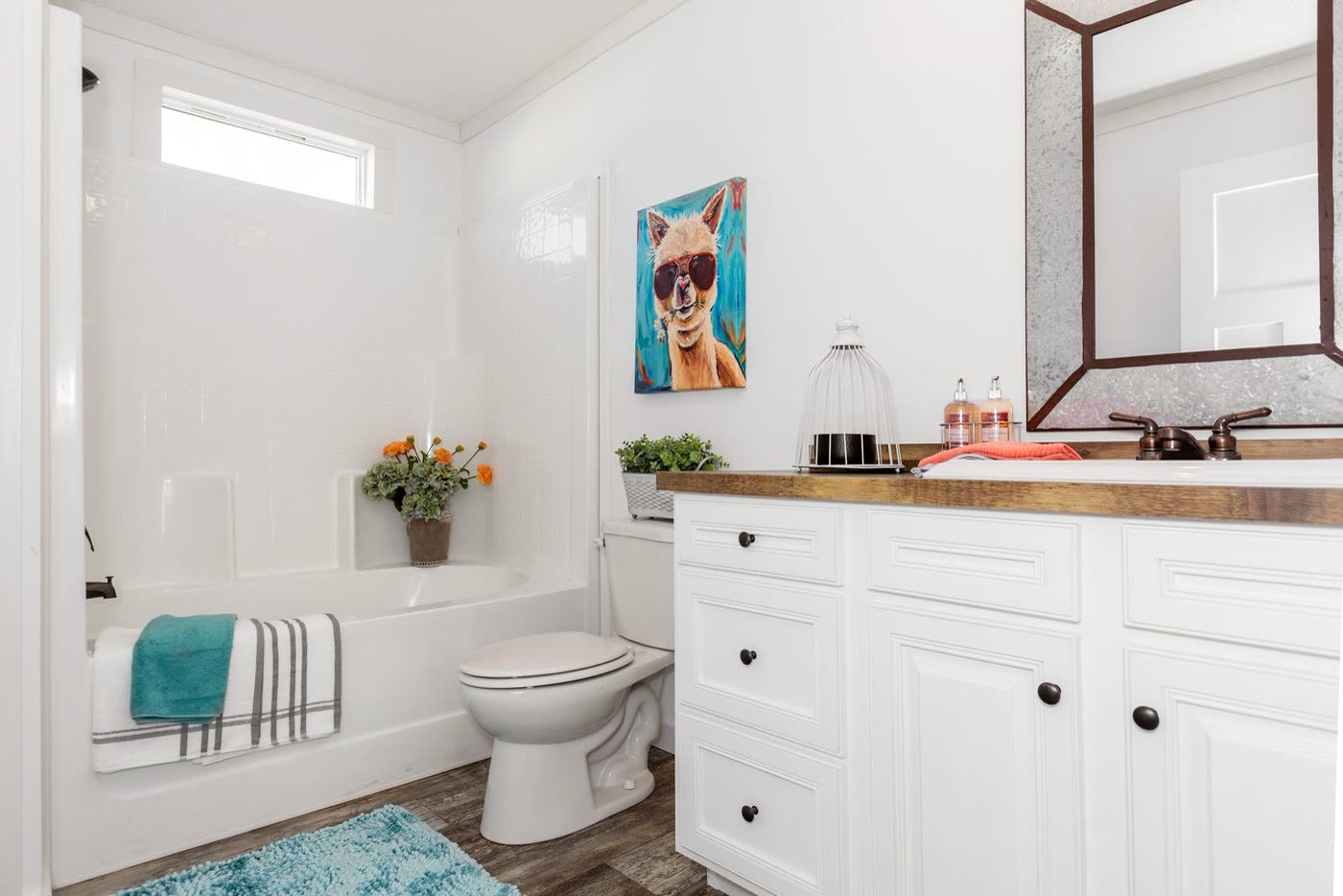 Guest bath. Tub with shower, toilet, wood-topped vanity, clerestory window.