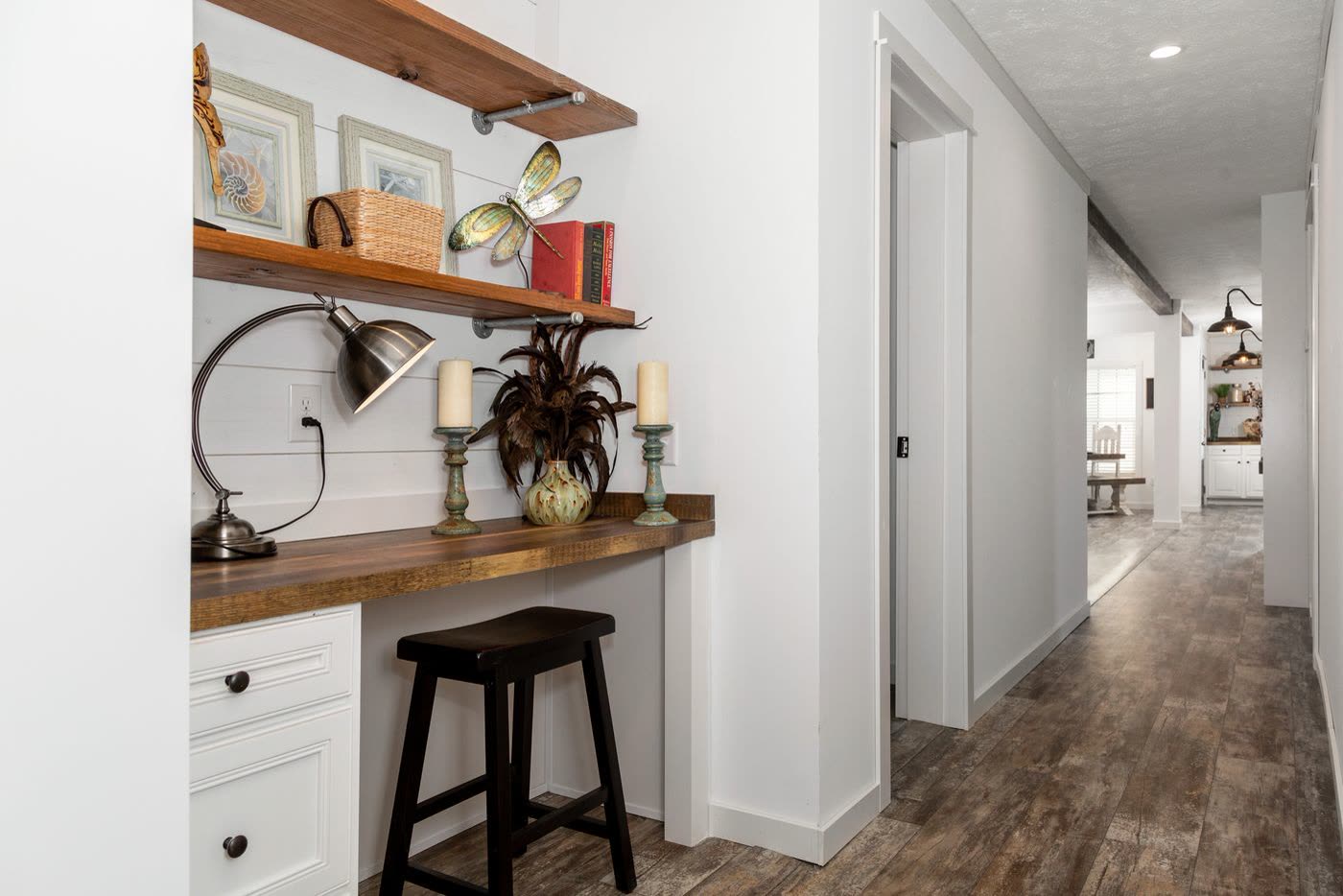 Study nook toward the hall. Desk and stool on the left, hallway to the bedrooms ahead.