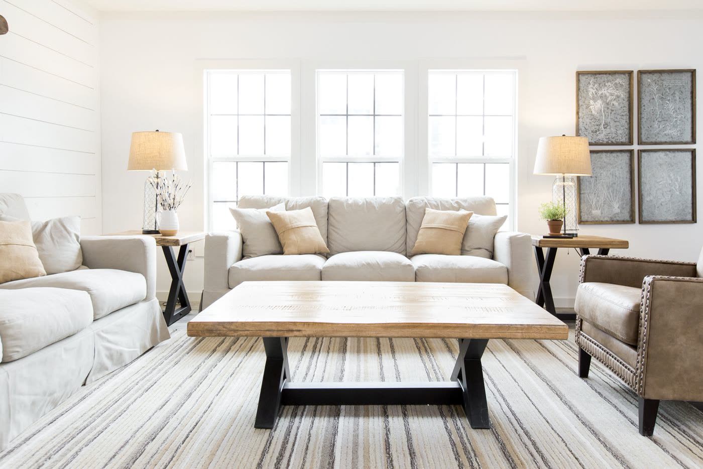 Living room, second furnishing. Sofa and coffee table between the windows.