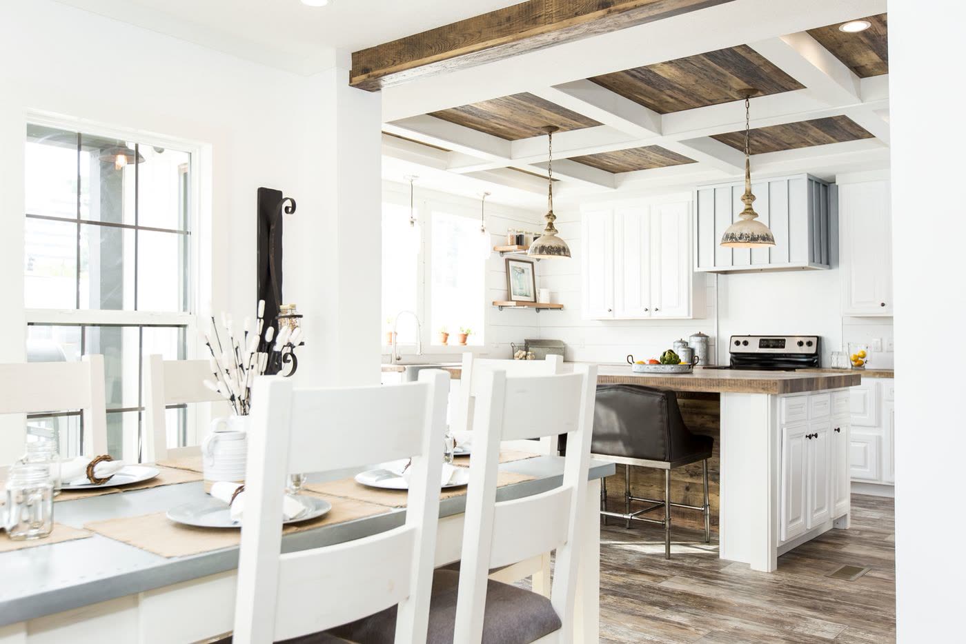 Dining toward the kitchen, second furnishing. Table in the foreground, island and range beyond.
