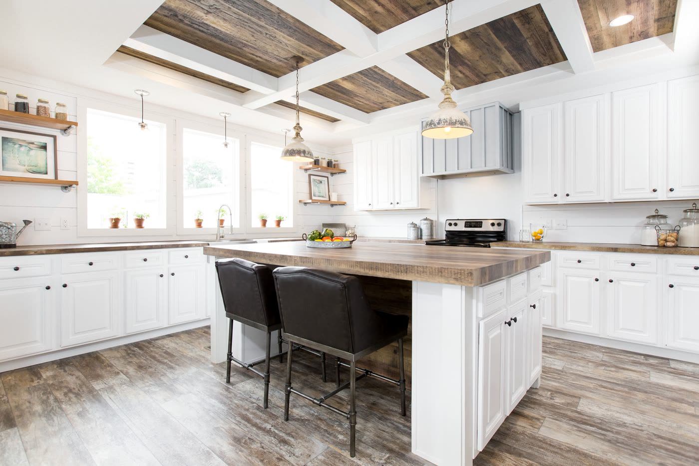 Kitchen, second furnishing. Island with black stools, coffered ceiling, windows over the counter.