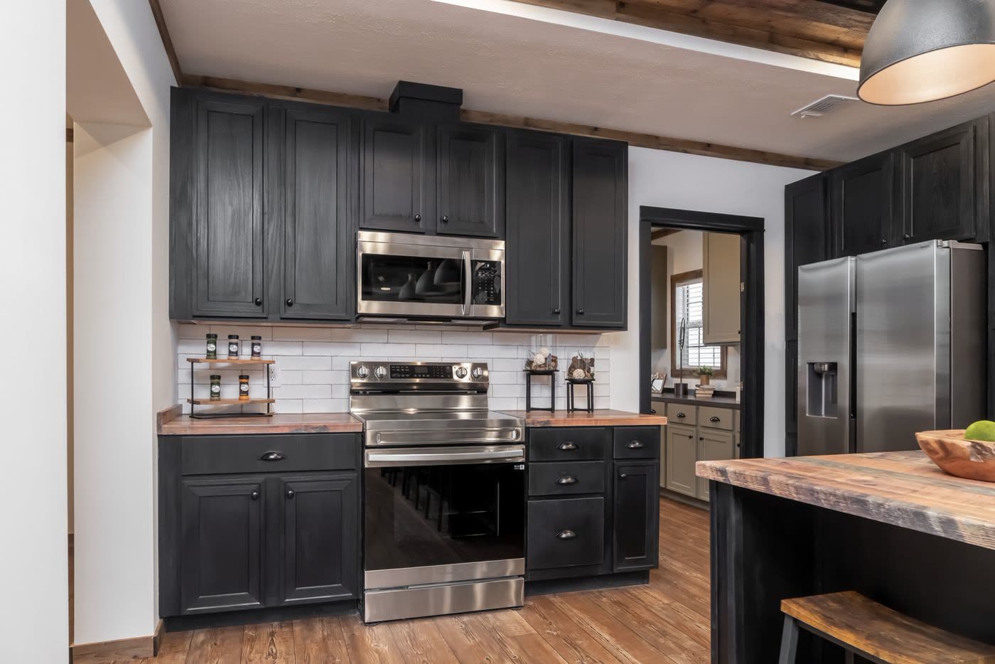 Kitchen. Range wall and refrigerator, doorway to the utility room at center.