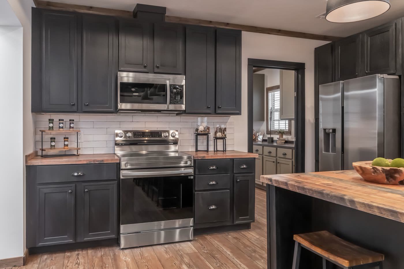 Kitchen from the island. Range wall, refrigerator, utility room beyond.