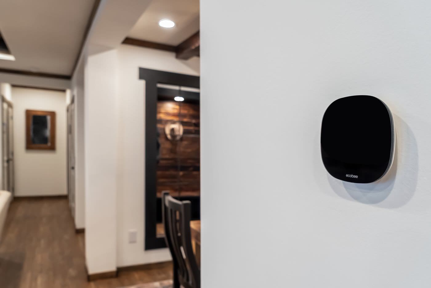 Hall. Thermostat, doorway at left, mirror at the far end.