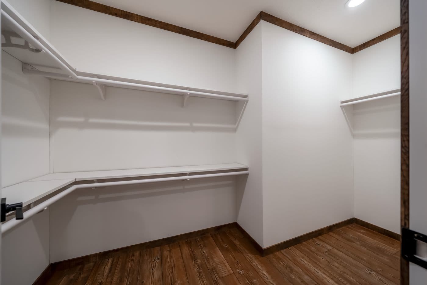 Walk-in closet. Shelving and rods on three walls.