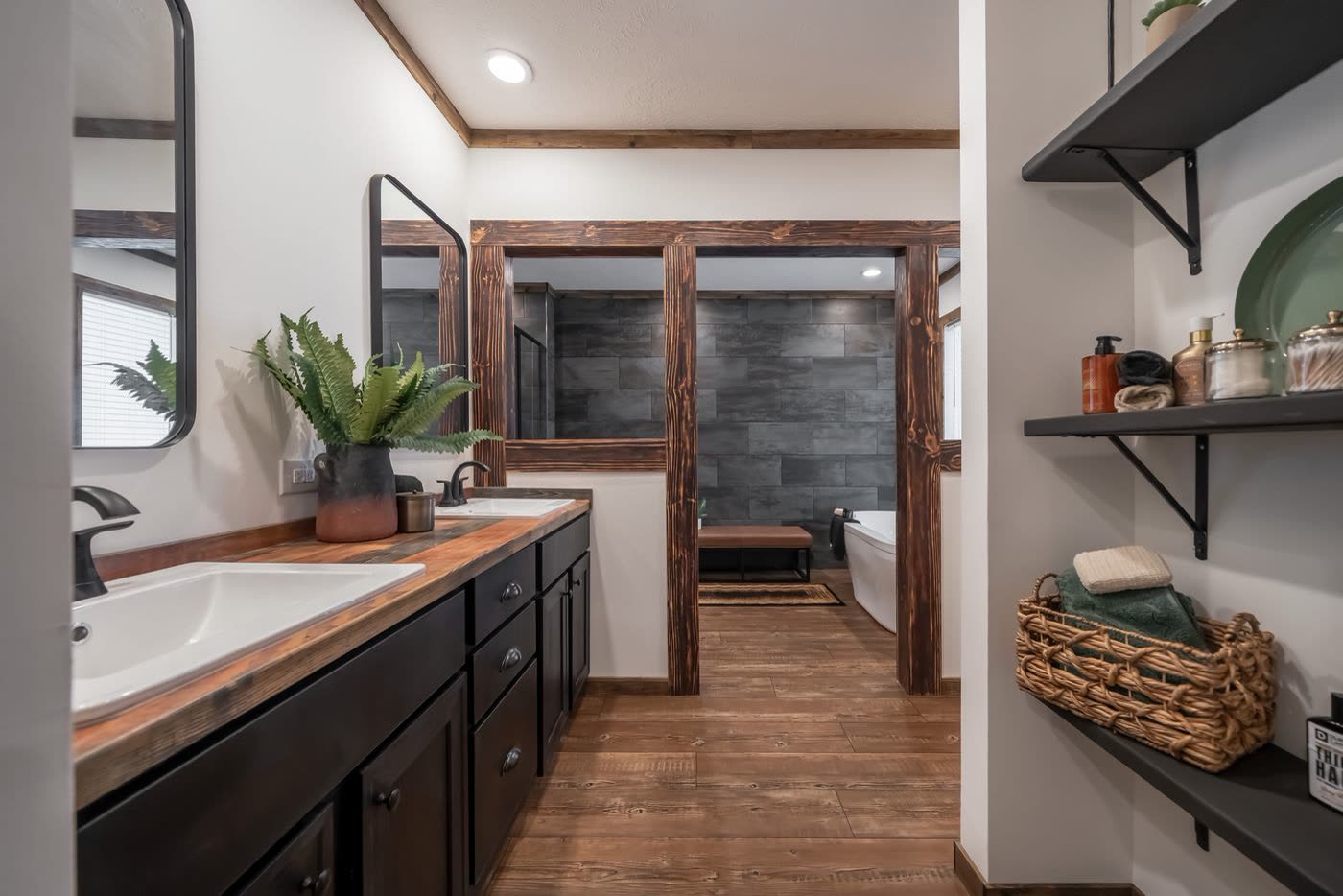 Primary bath. Double vanity, open shelves, tub room beyond.