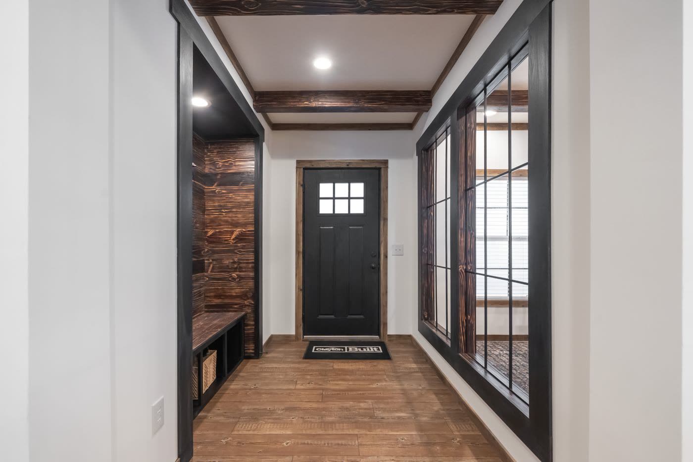 Foyer. Front door, glass partition to the dining room, bench and coat hooks at left.